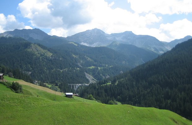 Foto con vista su una valle; in lontananza, un viadotto (ponte ferroviario).