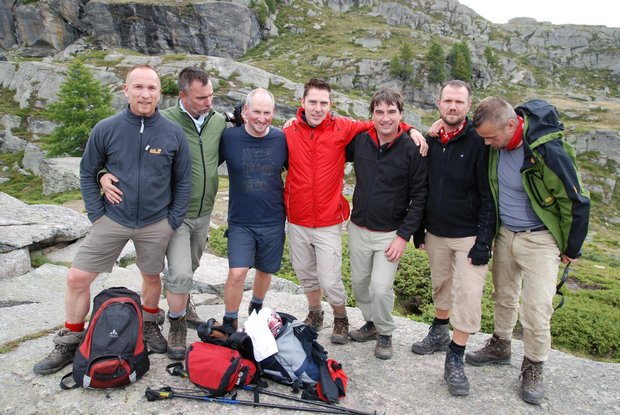 A group of 7 hikers look into the camera