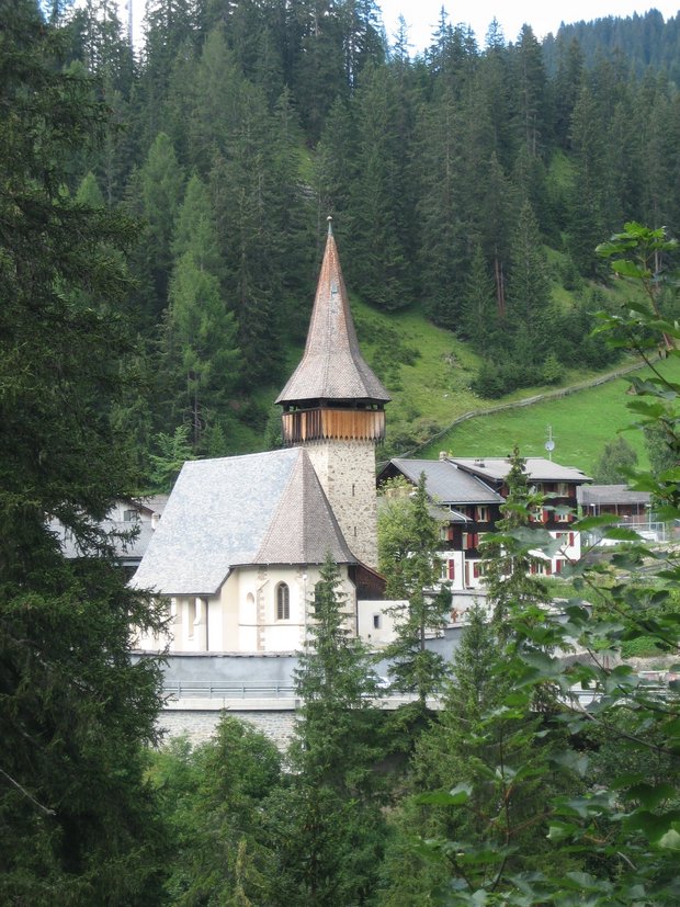 Foto di un villaggio di montagna con una chiesa e una casa sullo sfondo