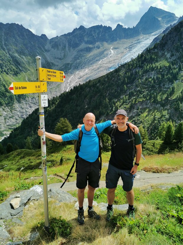 Manno and Stefan stand in front of a mountain panorama.